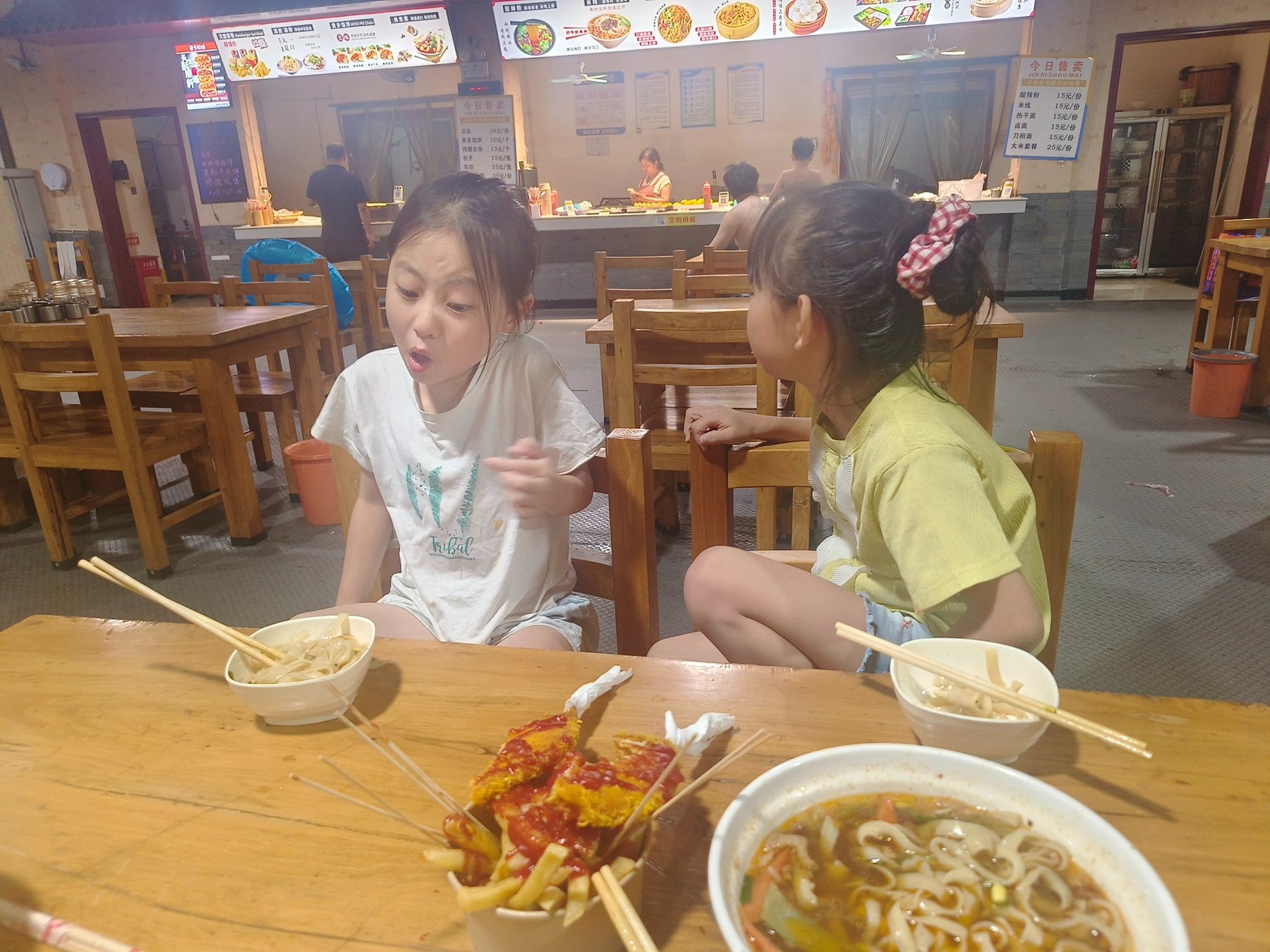 晚上九点左右，两个女孩坐在餐桌旁吃饭聊天