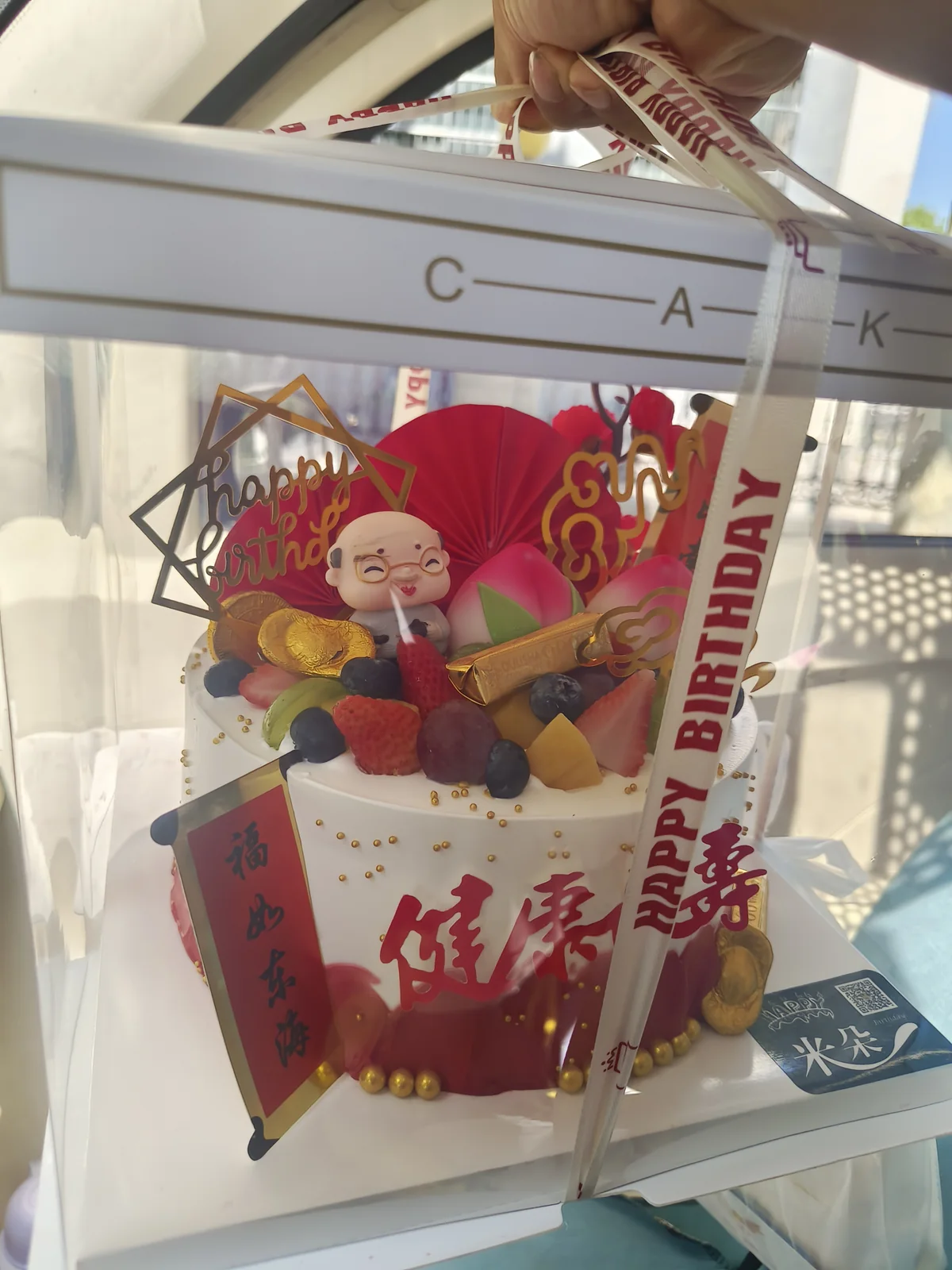 透明蛋糕盒中装着水果生日蛋糕