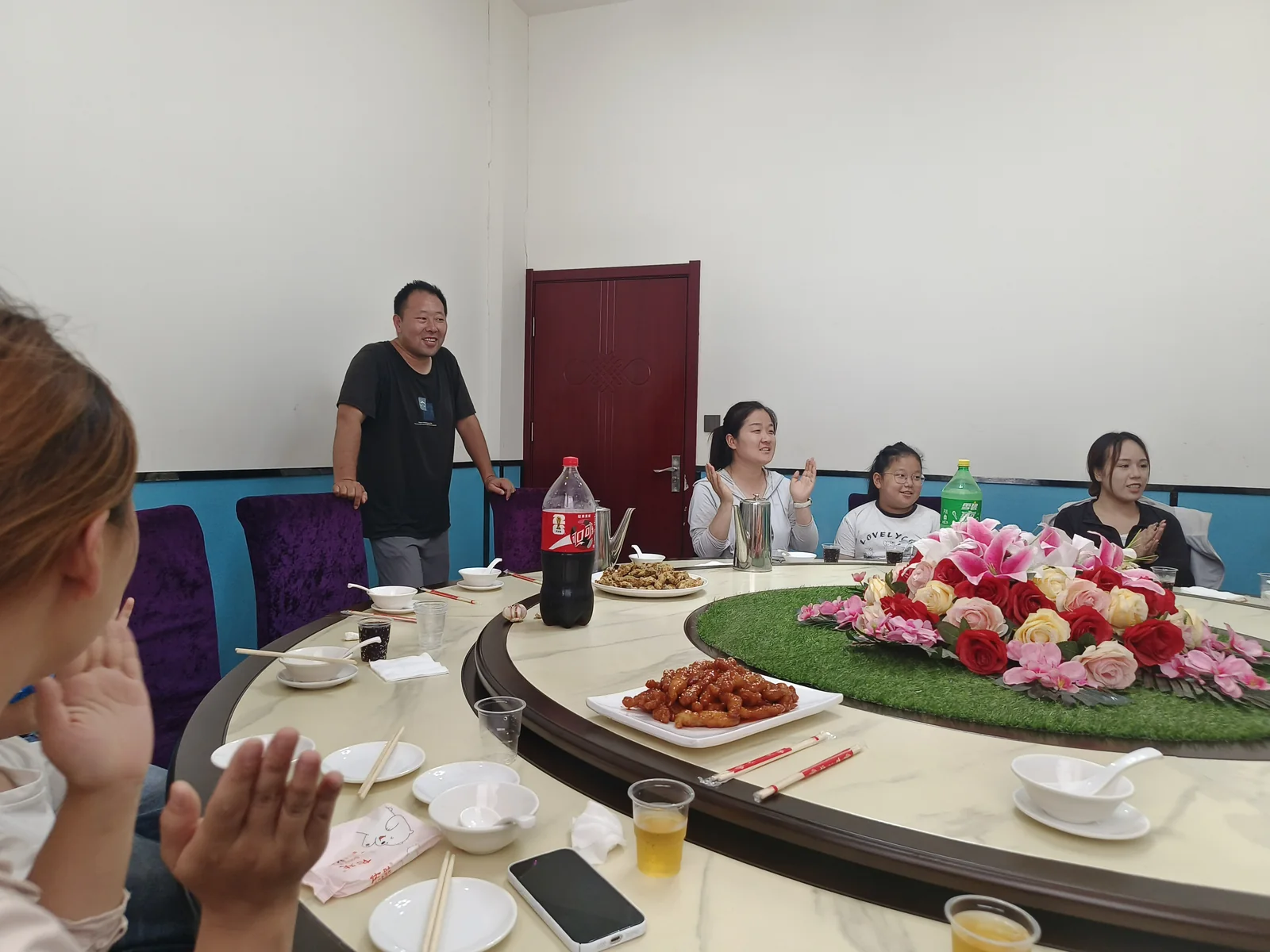 一位家人站在桌旁，几位家人拍手