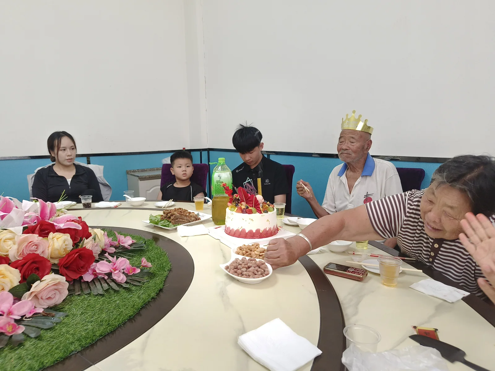 姥爷戴生日冠坐在圆桌旁