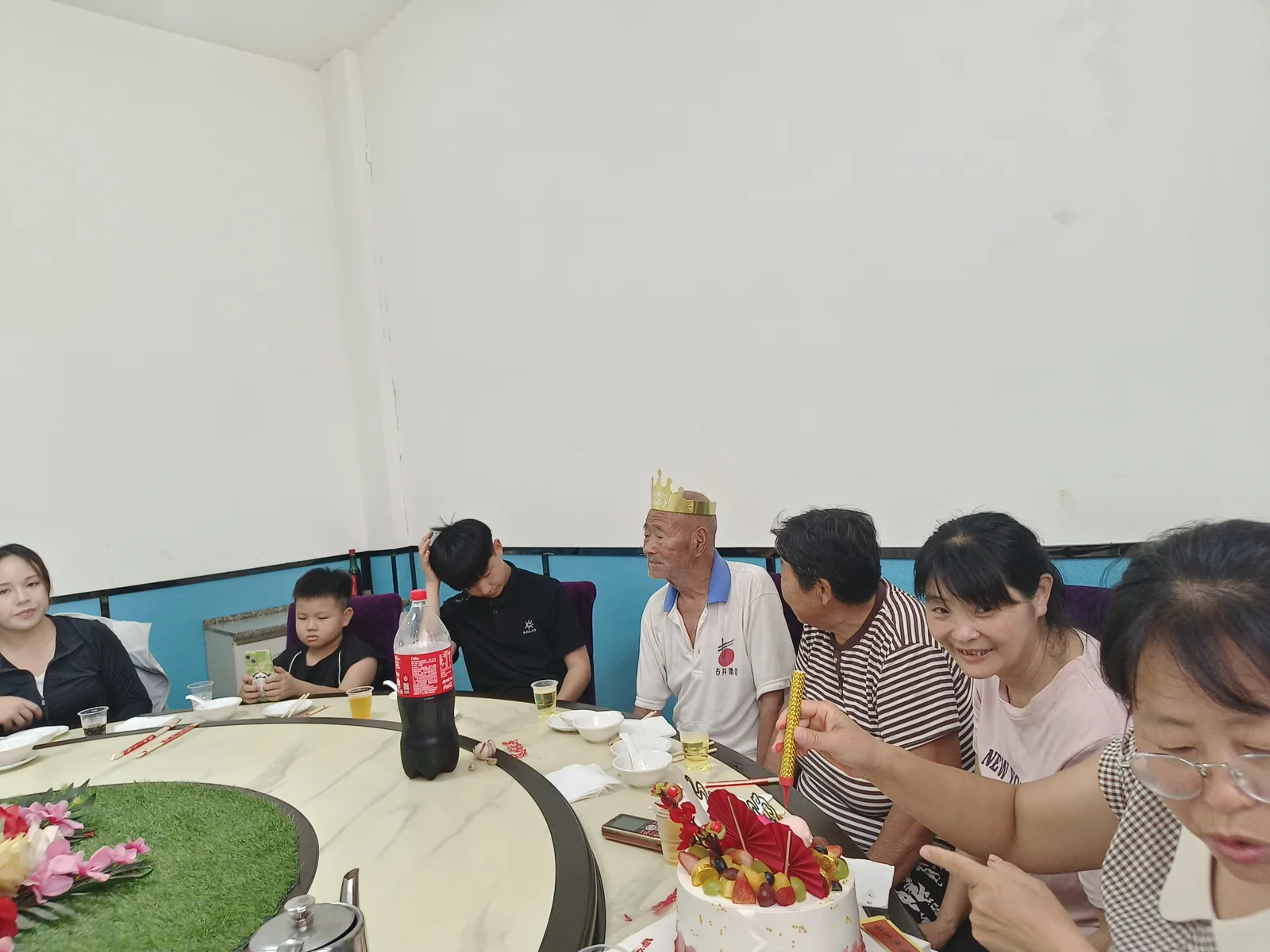 姥爷戴生日冠坐在家人中间
