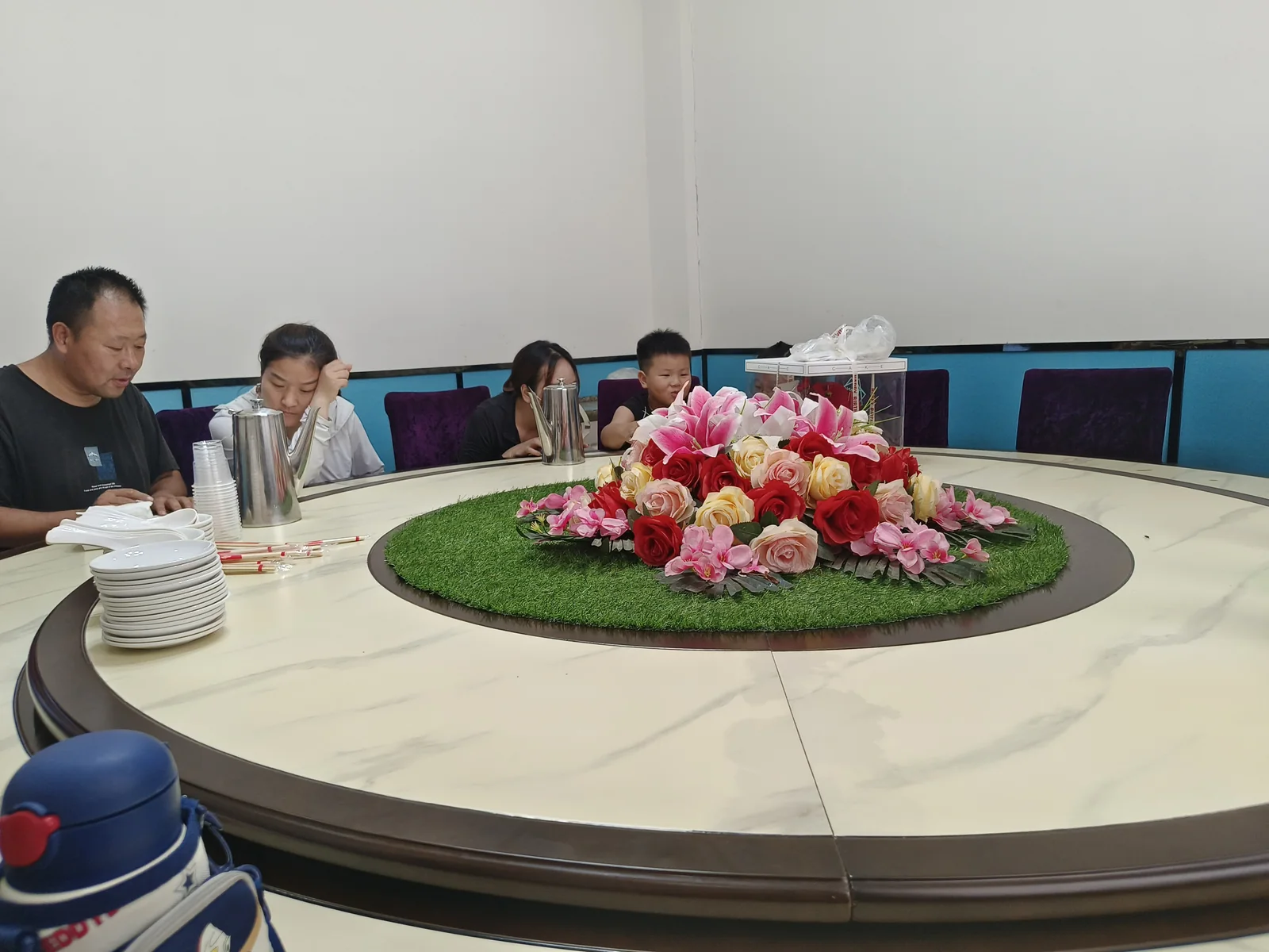 家人围坐，桌上有菜肴和餐具