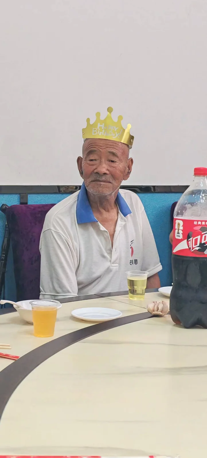 姥爷戴着金色生日冠坐在桌旁