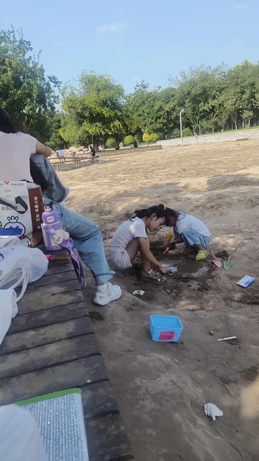 柔柔和表姐蹲在泥地边用小铲子和水玩泥