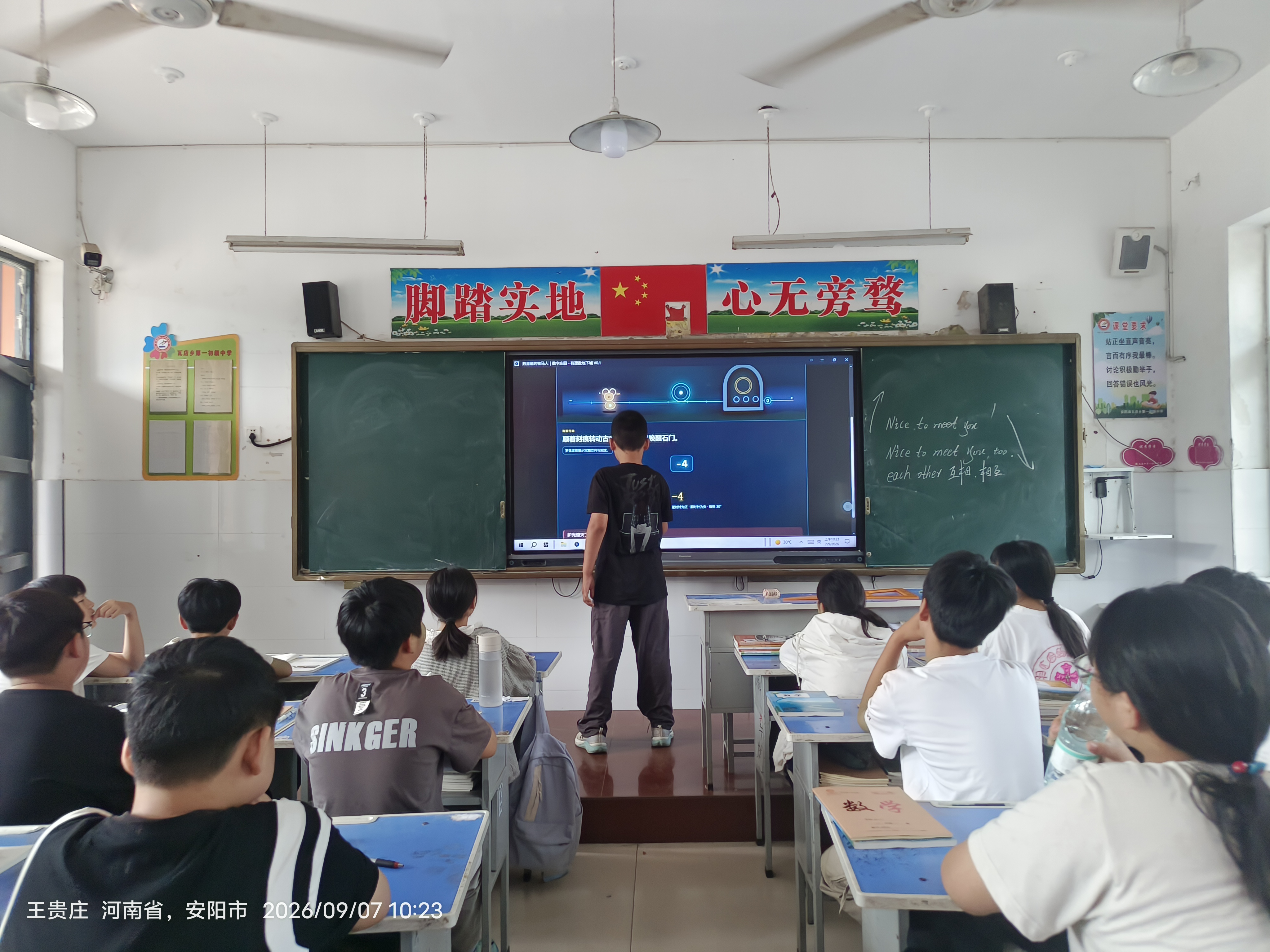 学生站在教室大屏幕前,屏幕显示有理数地下城圆盘机关,其他学生坐在课桌旁