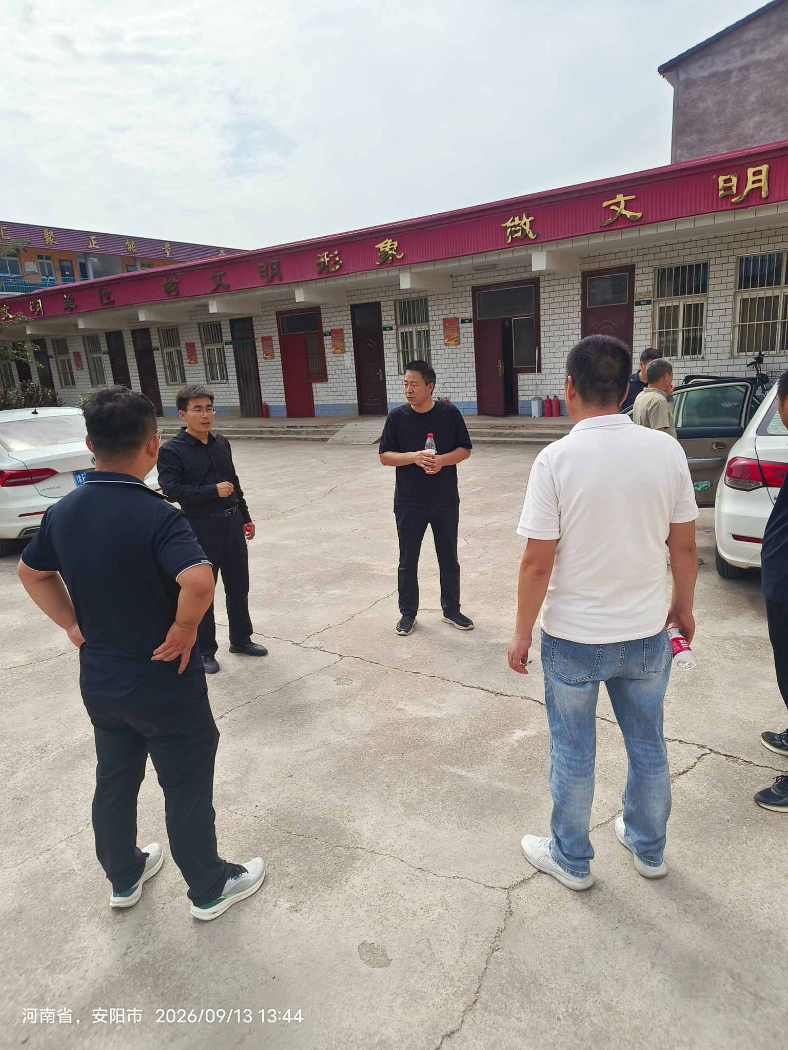 几位老师在校园院子里站着交流