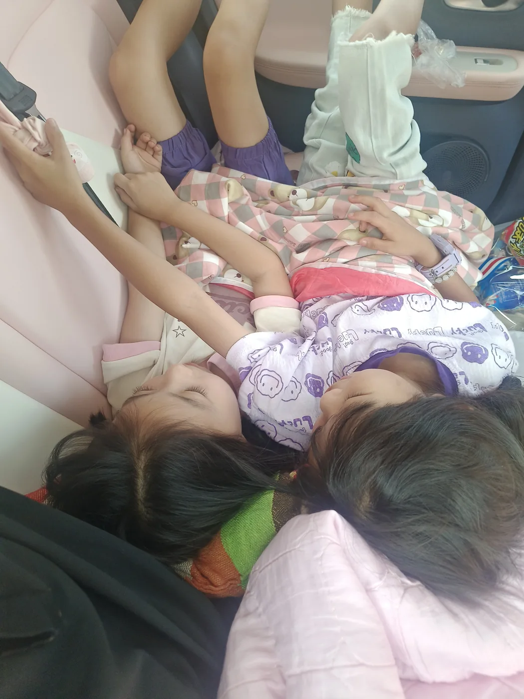 两个孩子在长途行车途中靠在一起休息