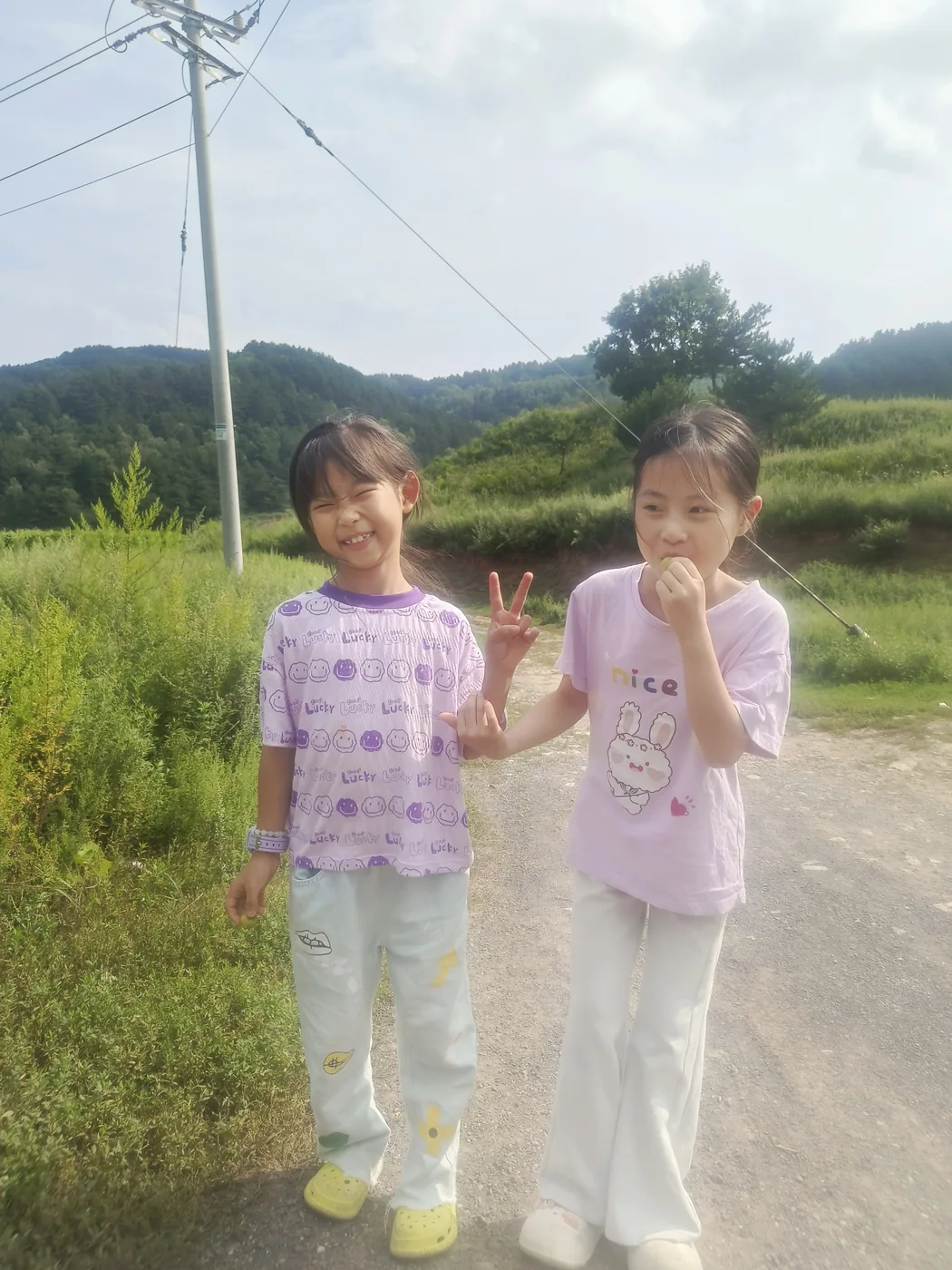 两个孩子在山地村落附近合影