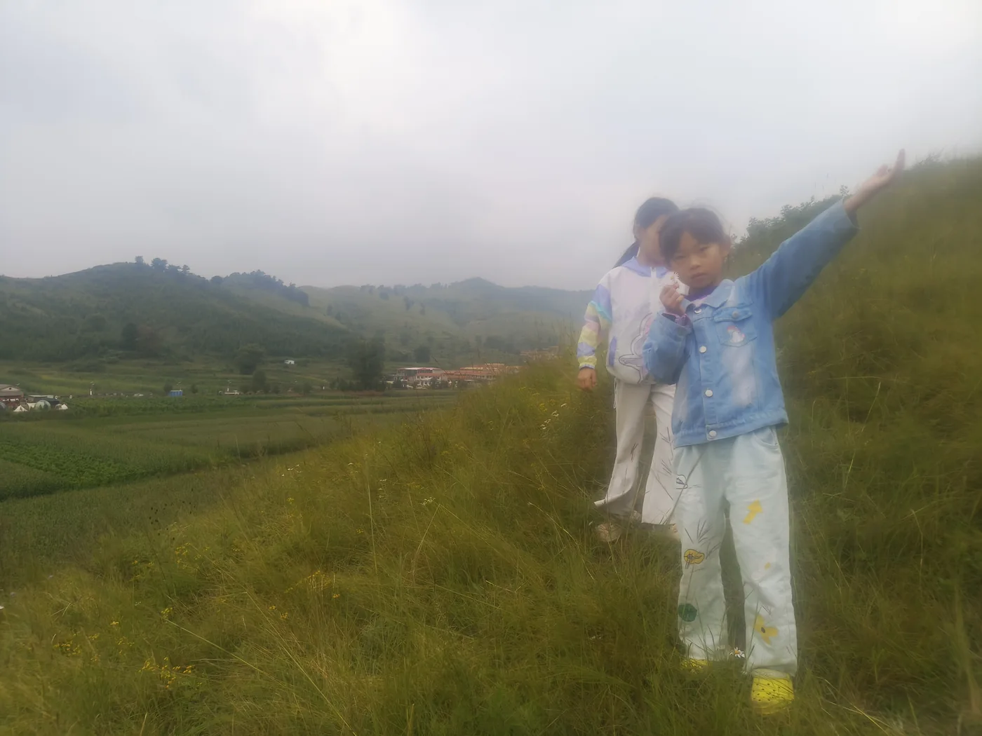孩子站在傍晚山坡上留影