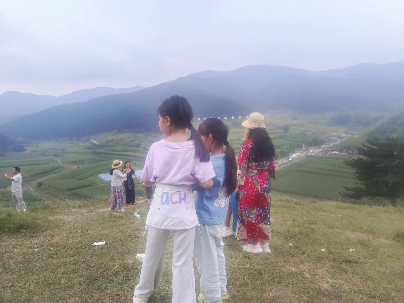 家人在山坡上合影,身后是傍晚山景