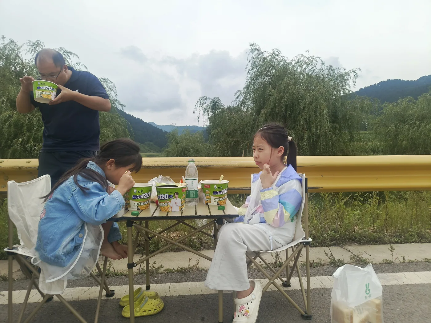 家人在山路边摆桌休息和吃午餐