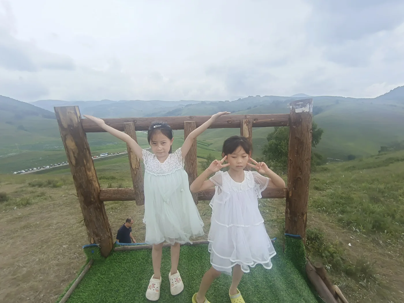 孩子们在草坡的秋千与框景装置旁玩耍