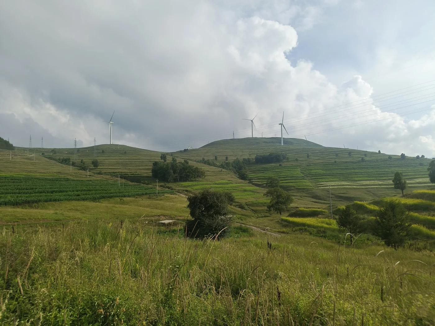 风机、田地与山路共同组成的山区风景